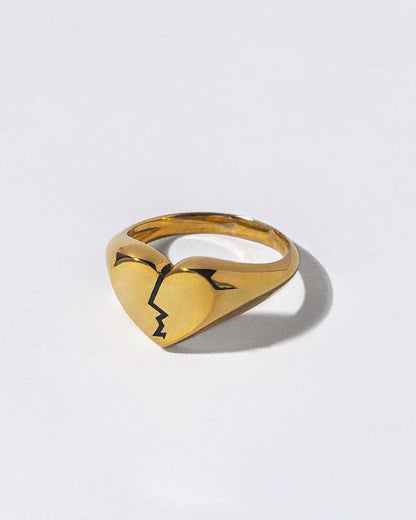 Gold ring with a broken heart design on a white background