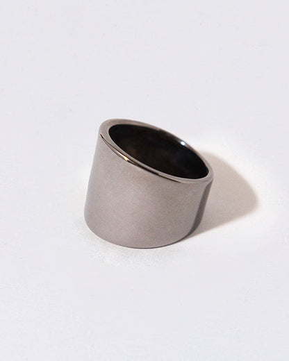 Silver ring with black rhodium plating on a light gray background
