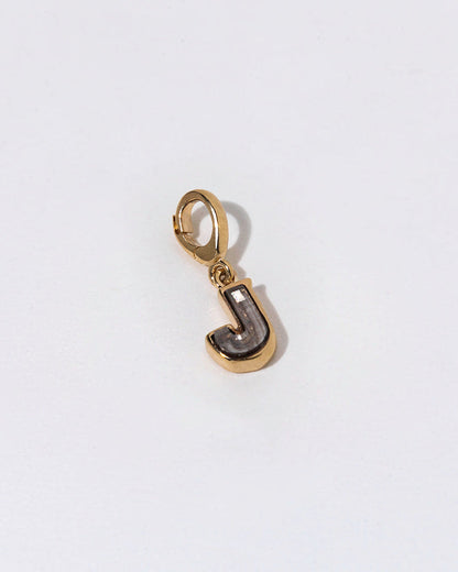 Gold charm with a diamond letter 'J' on a white background