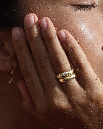Close-up of a hand with gold rings on a blurred background