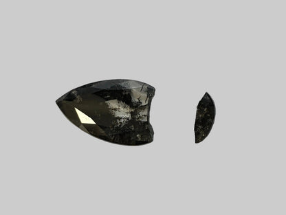 Two black gemstones on a light gray background