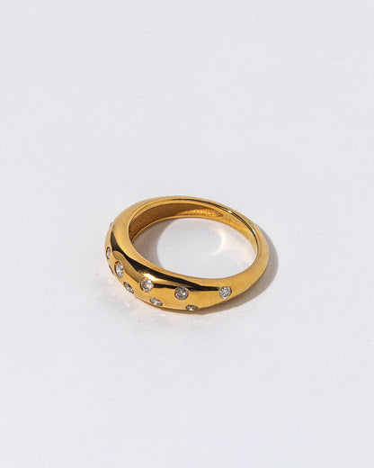 Gold ring with small diamonds on a light gray background