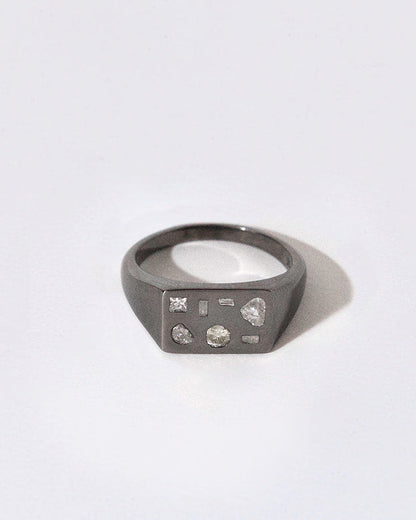 Black rhodium plated silver ring with embedded diamonds on a white background