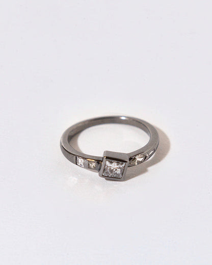 black rhodium plated silver ring with embedded diamonds on a white background