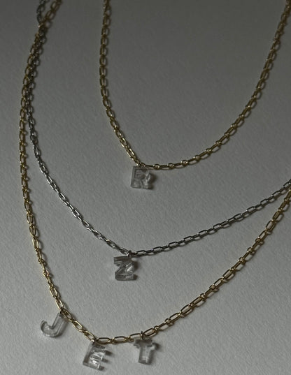 three necklaces with diamond letter charms 