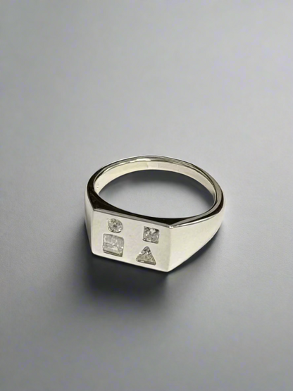 Silver ring with embedded diamonds on a gray background