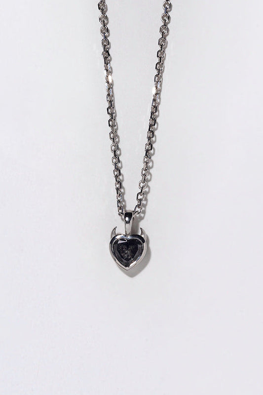 Silver necklace with a heart-shaped salt and pepper diamond with devil horns on a white background