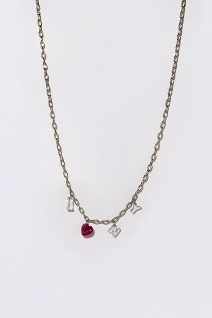 A silver chain with white diamonds and a heart ruby spelling out 'I Love N Y" on a white background