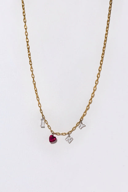 A gold chain with white diamonds and a heart ruby spelling out 'I Love N Y" on a white background