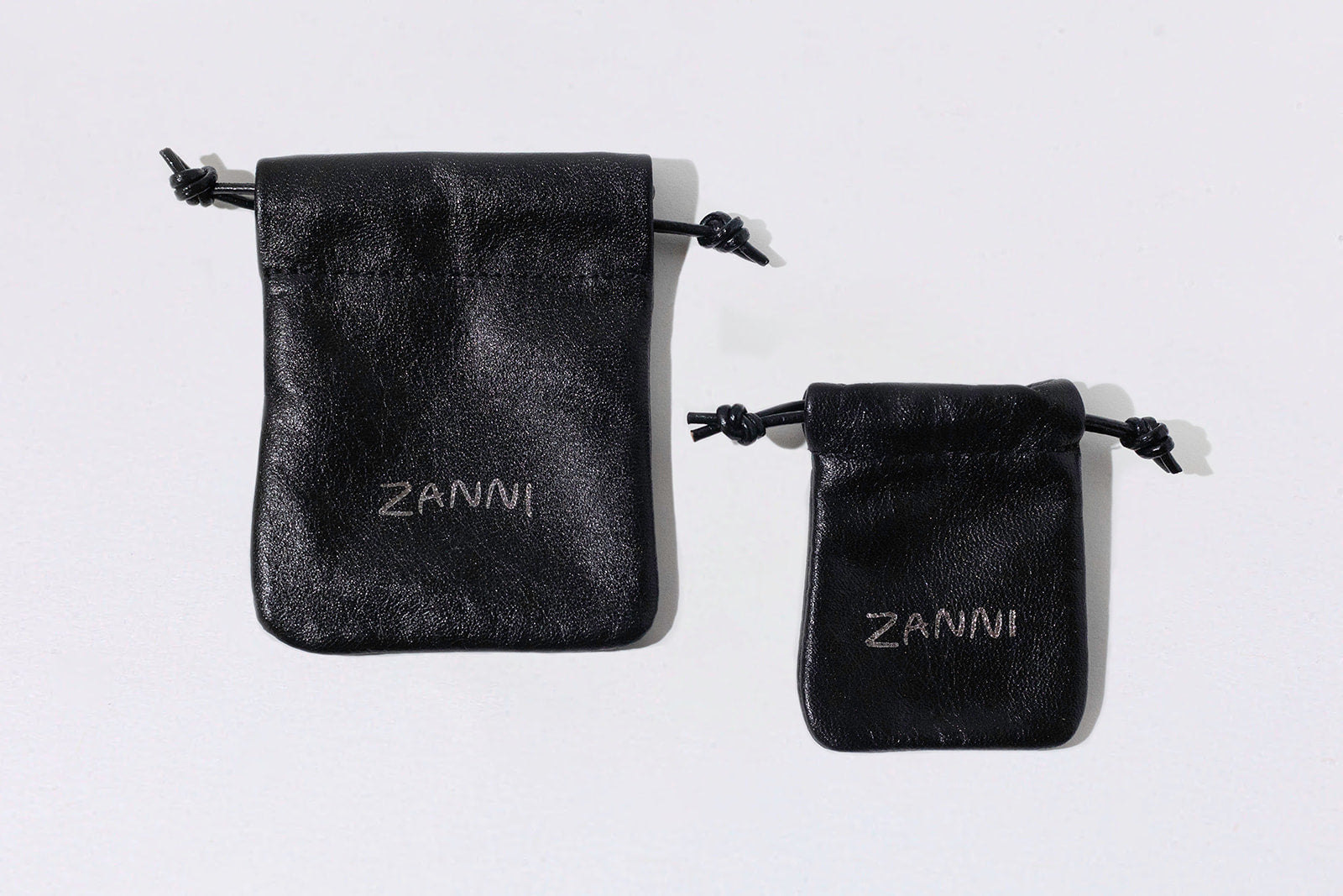 Two black velvet pouches with 'Zanni' branding on a white background