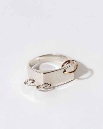 Silver ring with three piercings in silver and gold on a white background