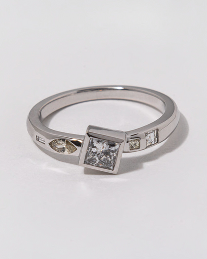 Silver ring with white diamonds embedded on a white background