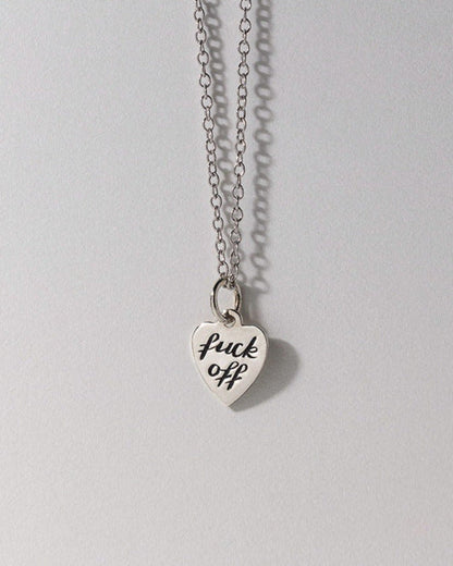 Silver necklace with a heart-shaped pendant on a gray background