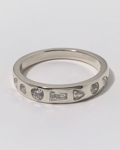 Silver ring with embedded diamonds on a light gray background