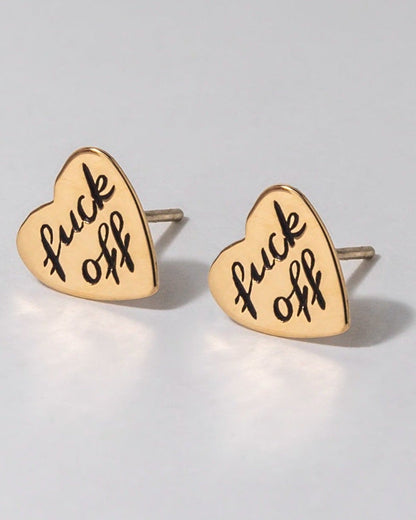 Heart-shaped earrings with 'fuck off' text on a light gray background